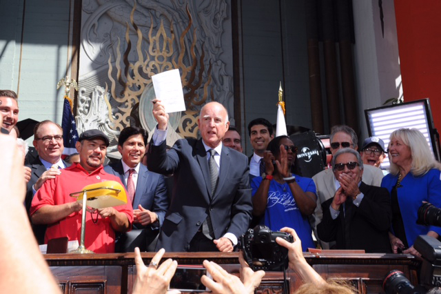 With much fanfare from the local entertainment industry, Gov. Jerry Brown signs AB 1839 into law at a ceremony outside the TCL Chinese Theatre in Hollywood Sept. 18. Photo: Courtesy IATSE Local 600
